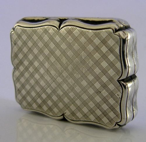 An open Victorian sterling silver vinaigrette box by Nathaniel Mills featuring a scalloped edge, cross-hatch engraving, and an internal hinged pierced gilt grill. View IX