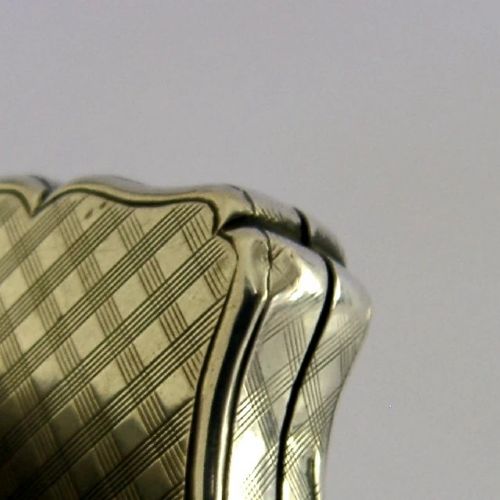 An open Victorian sterling silver vinaigrette box by Nathaniel Mills featuring a scalloped edge, cross-hatch engraving, and an internal hinged pierced gilt grill. View XII