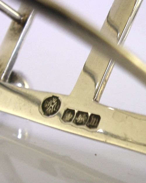 A sterling silver six-slice toast rack featuring seven arched wire divisions, a central loop handle, and four ball feet resting on a rectangular base. View VIII