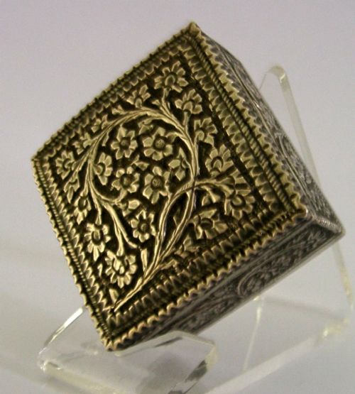 An open square solid silver box featuring detailed floral scroll repousse work across its exterior surface. View III