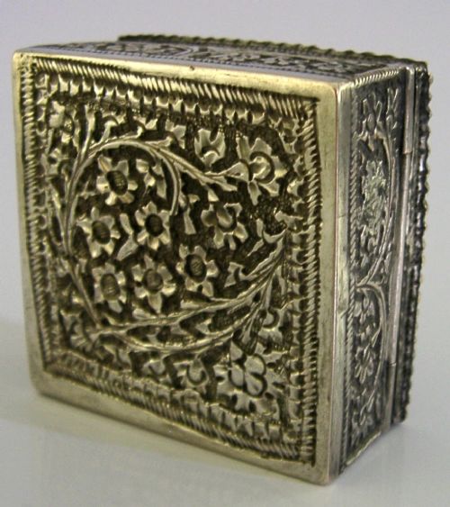 An open square solid silver box featuring detailed floral scroll repousse work across its exterior surface. View V