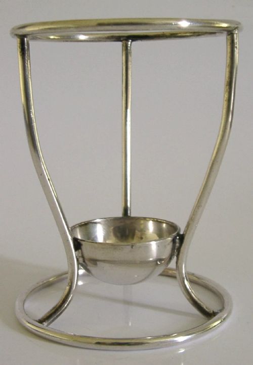A Victorian silver-plated wirework stand designed to hold a Hamilton torpedo bottle, featuring a circular base, curved uprights, a top ring, and a central cup. View VII