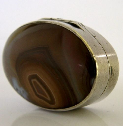 An open Georgian silver oval vinaigrette box featuring a translucent banded agate lid insert and a perforated gold-gilded floral inner grille. View V