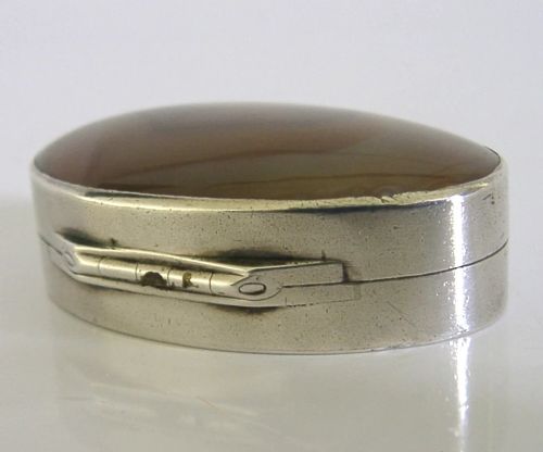 An open Georgian silver oval vinaigrette box featuring a translucent banded agate lid insert and a perforated gold-gilded floral inner grille. View X
