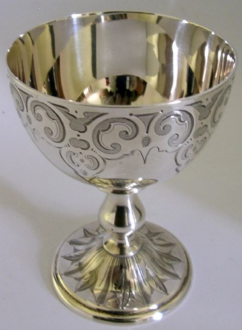 A mid-Victorian sterling silver chalice featuring an engraved scroll pattern around the cup, a central knopped stem, and a leaf-patterned circular base. View IV