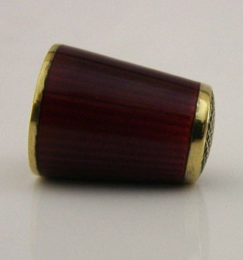A mid-century Norwegian sterling silver thimble featuring rich red translucent guilloche enamel and a gilded waffle-patterned top. View IV