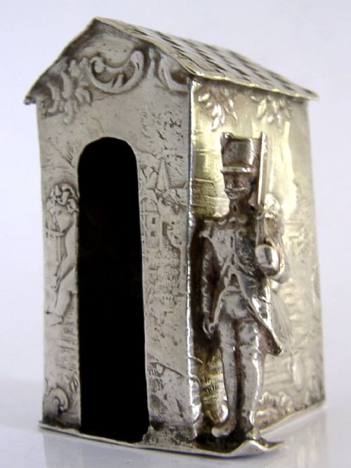 An antique Hanau silver miniature sentry post featuring a uniformed soldier guard standing beside an arched entryway with chased decorative detailing. View V