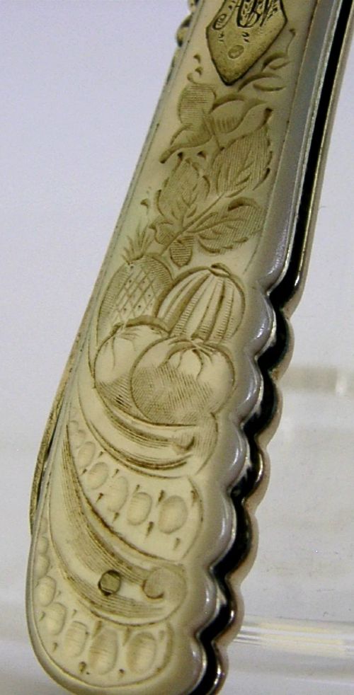 An Edwardian folding fruit knife with a carved mother-of-pearl handle and engraved silver shield cartouche. View II