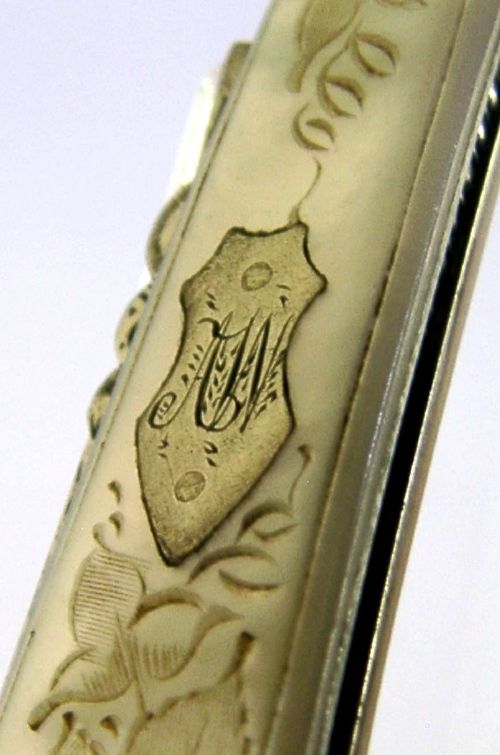An Edwardian folding fruit knife with a carved mother-of-pearl handle and engraved silver shield cartouche. View III
