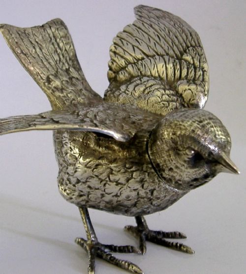 A solid silver pepper pot finely chased in the detailed form of a bird chick with outstretched wings. View II