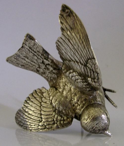 A solid silver pepper pot finely chased in the detailed form of a bird chick with outstretched wings. View VII