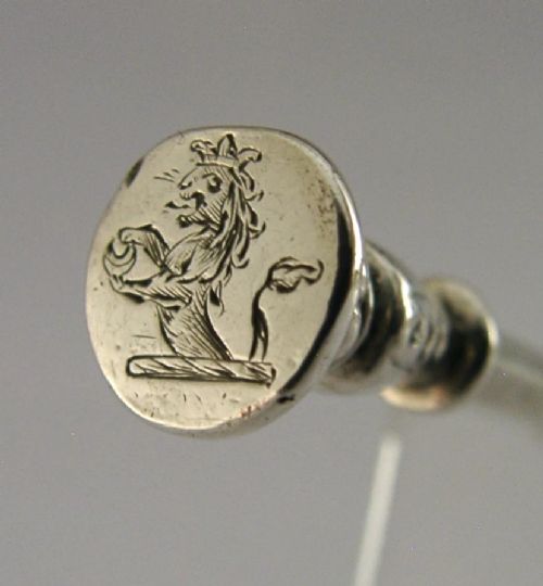A Victorian sterling silver seal top fork featuring four tines and hallmarks along the slender stem. View II