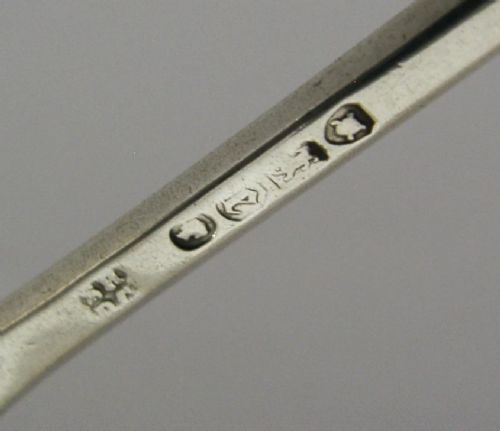 A Victorian sterling silver seal top fork featuring four tines and hallmarks along the slender stem. View VIII