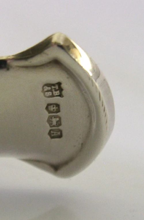 A sterling silver tea caddy spoon shaped like an open human hand with visible hallmarks stamped near the wrist handle. View VII