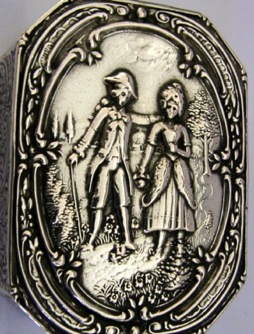 An octagonal antique silver table box featuring a detailed repousse scene of a couple in 18th-century attire within a scrollwork frame. View II