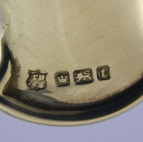 An Edwardian sterling silver tea caddy spoon crafted in the shape of a cupped human hand with an engraved monogram letter K and visible British hallmarks. View VI