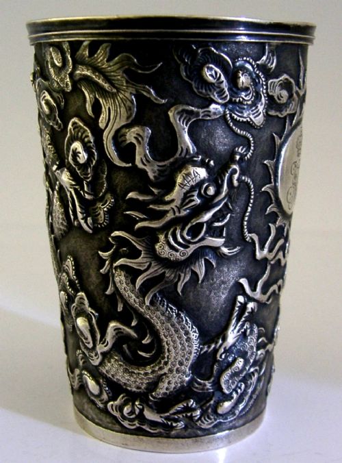 A cylindrical Chinese export silver beaker featuring high-relief repousse dragon motifs and an oval cartouche engraved with a royal monogram beneath a crown. View III