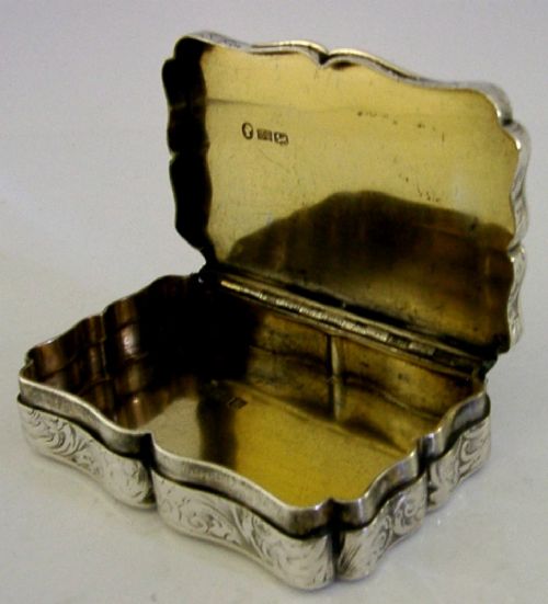 An engraved Victorian sterling silver snuff box with shaped edges, scrollwork border, and engraved inscription on the lid. View III