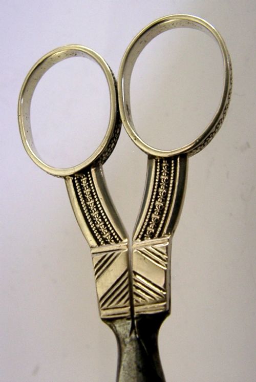 A pair of 19th-century Dutch solid silver needlework scissors featuring engraved oval finger loops and steel blades. View III