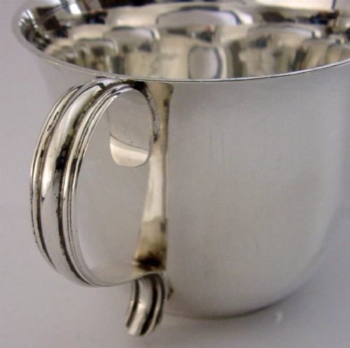 A polished sterling silver porringer bowl featuring a flared rim, rounded body, and twin loop side handles. View II