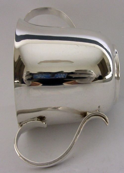 A polished sterling silver porringer bowl featuring a flared rim, rounded body, and twin loop side handles. View III
