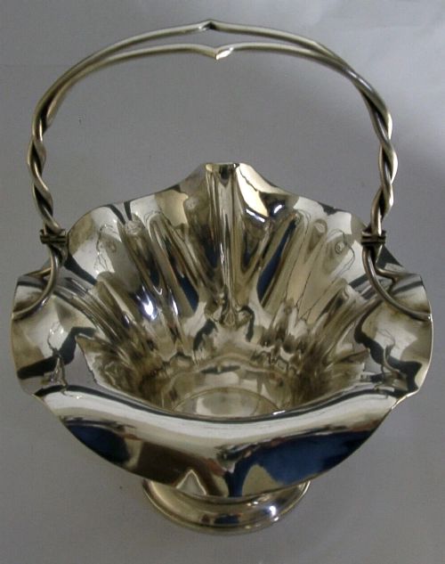 An antique solid silver Art Nouveau basket bowl with a fluted, lobed rim and an overhead twisted wire swing handle. View III