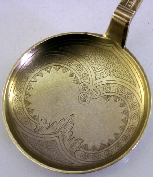 An antique Danish solid silver gilt serving spoon featuring an engraved circular bowl, a twisted stem, and a decorative finial. View IV