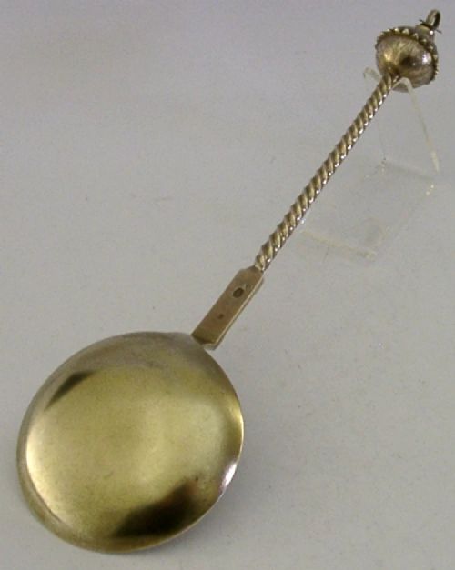 An antique Danish solid silver gilt serving spoon featuring an engraved circular bowl, a twisted stem, and a decorative finial. View VIII