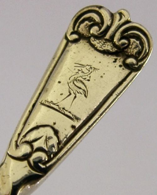 Victorian sterling silver sugar sifter spoon featuring a twisted stem, shell-shaped pierced bowl, and engraved heron crest handle terminal. View III