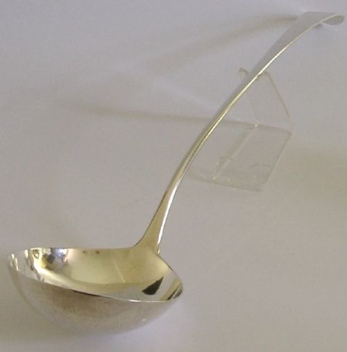 A Georgian sterling silver soup ladle featuring a rounded bowl, long handle, and engraved heraldic crest. View II