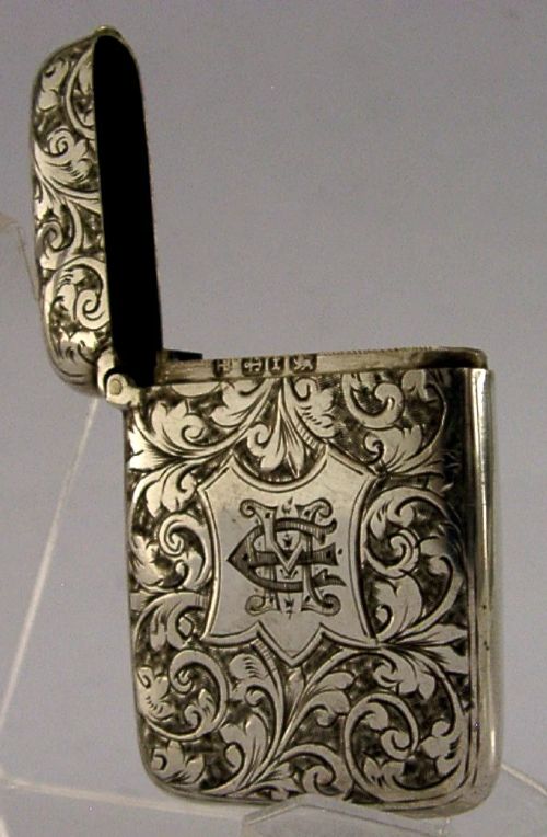 Victorian sterling silver vesta case decorated with hand-engraved foliate scrollwork and a central monogrammed shield cartouche. View VI