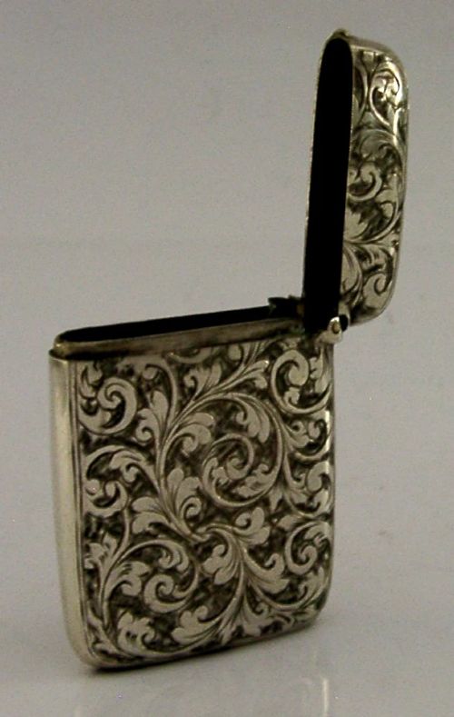 Victorian sterling silver vesta case decorated with hand-engraved foliate scrollwork and a central monogrammed shield cartouche. View VII