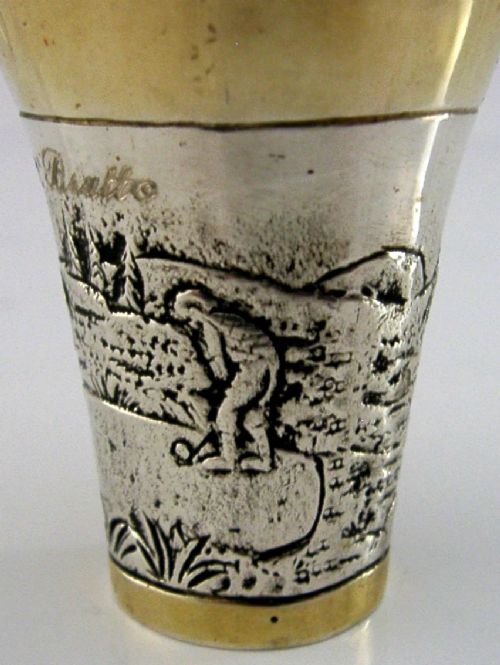 An antique 800 solid silver beaker with gilded rims featuring an embossed relief scene of a golfer. View II
