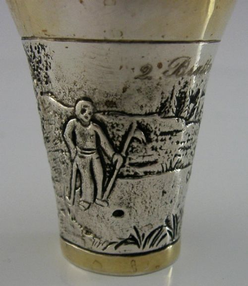An antique 800 solid silver beaker with gilded rims featuring an embossed relief scene of a golfer. View III
