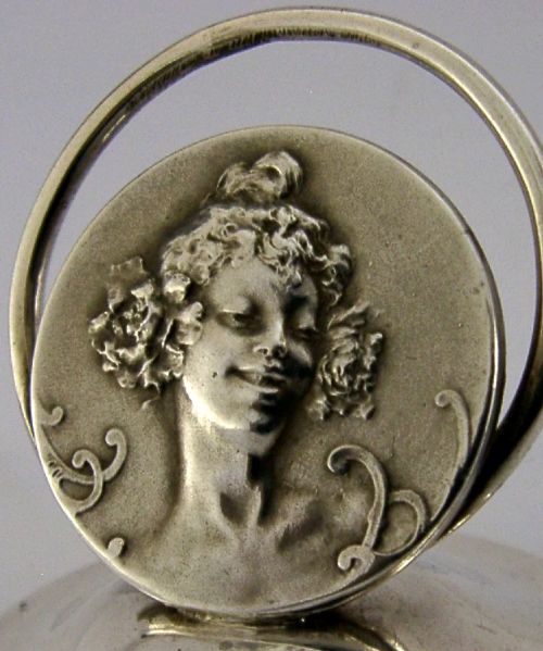 An Edwardian sterling silver menu holder featuring a circular relief of a maidens head set within an oval ring atop a domed base bearing British hallmarks. View II