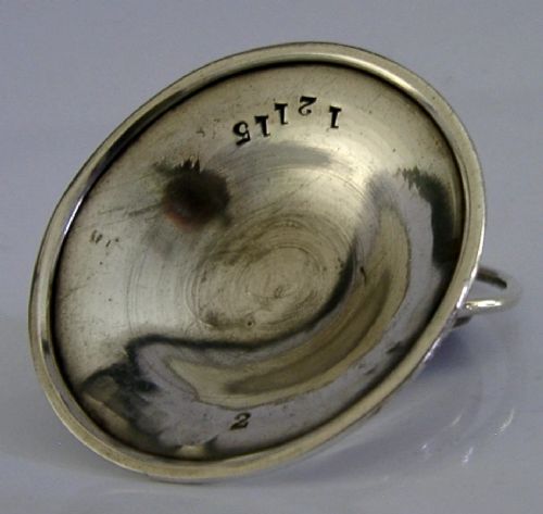 An Edwardian sterling silver menu holder featuring a circular relief of a maidens head set within an oval ring atop a domed base bearing British hallmarks. View VI