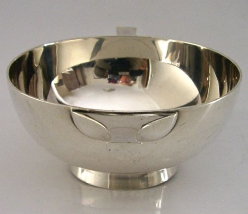 A polished sterling silver shallow drinking cup featuring two flat side handles and British hallmarks stamped on the exterior wall. View IV