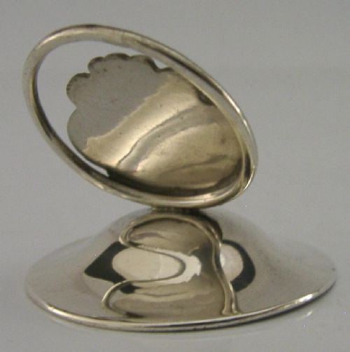 An Art Nouveau sterling silver menu holder featuring a relief profile of a maiden with flowing hair framed by a circular wire loop. View V