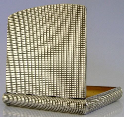 An open sterling silver case displaying an engine-turned grid pattern on the exterior and a gilt metallic interior. View III