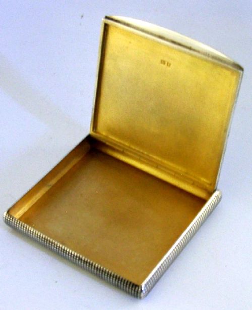 An open sterling silver case displaying an engine-turned grid pattern on the exterior and a gilt metallic interior. View IV