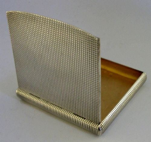 An open sterling silver case displaying an engine-turned grid pattern on the exterior and a gilt metallic interior. View V