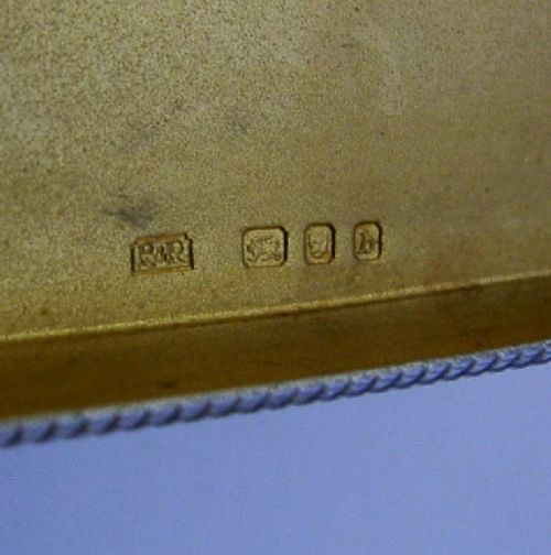 An open sterling silver case displaying an engine-turned grid pattern on the exterior and a gilt metallic interior. View VIII