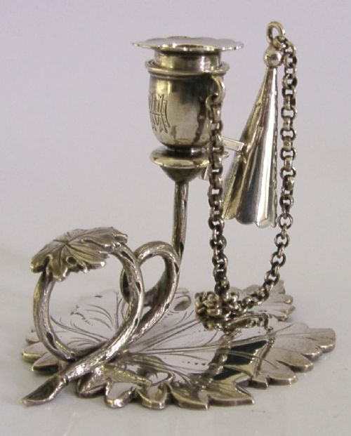 An early Victorian sterling silver chamberstick featuring a shaped leaf base, a coiled vine handle, and an attached chain with a conical snuffer. View VI