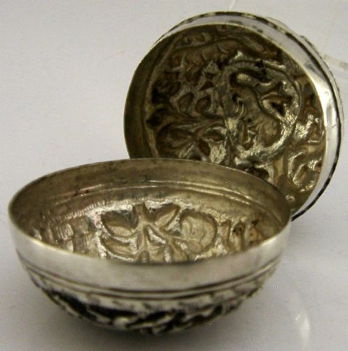 A circular solid silver box with relief repousse carvings depicting an elephant and palm trees in a jungle landscape. View VII