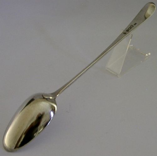An 18th-century Georgian sterling silver basting spoon featuring a long, tapered stem and a polished oval bowl. View V