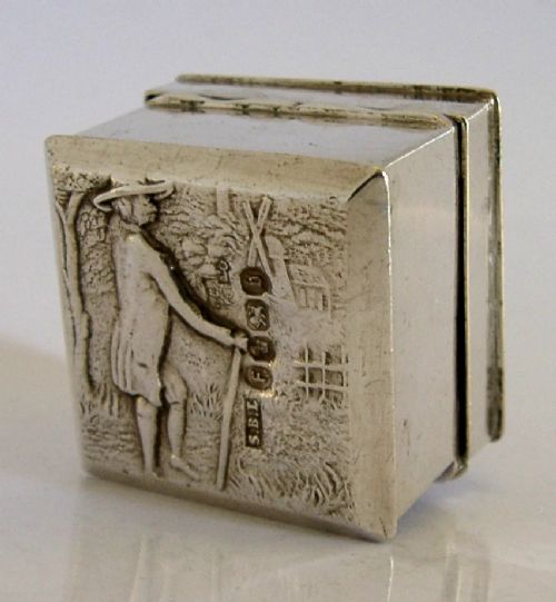 A small rectangular sterling silver box with a hinged lid featuring a raised relief scene of a figure walking a dog near a rustic building. View IV