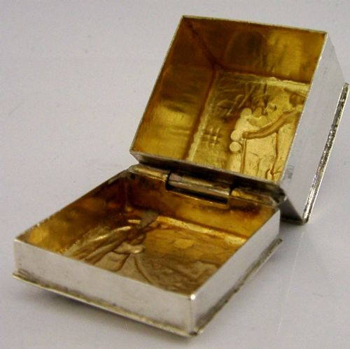 A small rectangular sterling silver box with a hinged lid featuring a raised relief scene of a figure walking a dog near a rustic building. View V