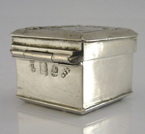 A small rectangular sterling silver box with a hinged lid featuring a raised relief scene of a figure walking a dog near a rustic building. View IX