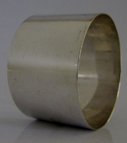 A polished sterling silver napkin ring featuring a circular colourful enamel plaque depicting Victoria Falls. View II