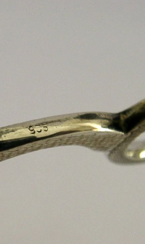 An opened oval fitted leather case displaying an Edwardian sterling silver sewing kit with scissors, thimble, bodkin, and needle case. View VII